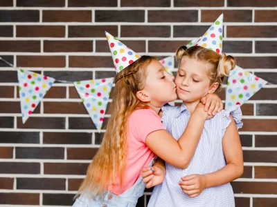 vecteezy_two-girls-in-holiday-hats-hugging-and-saying-happy-holidays_51191302