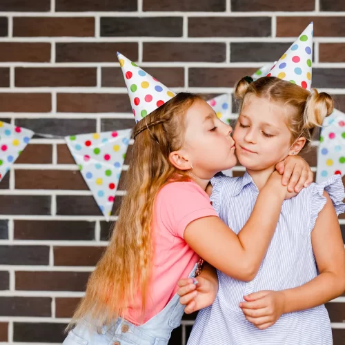 vecteezy_two-girls-in-holiday-hats-hugging-and-saying-happy-holidays_51191302